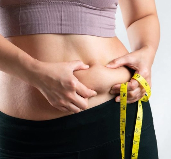Person checking waistline with a measuring tape